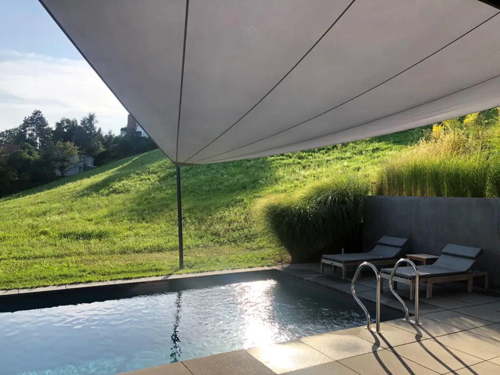 Elektrisch aufrollbares Sonnensegel über einem Pool in Grünlage – Galeriebild 2/3 – SDS – Einfamilienhaus Graz