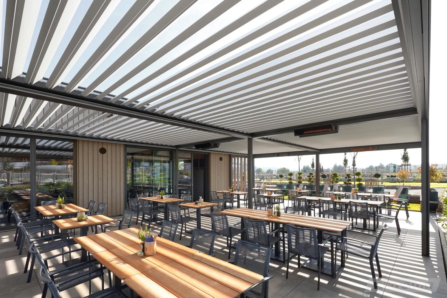 Terrasse eines Gastronomiebetriebs mit offenem Lamellendach